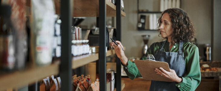 Middle-aged woman checking the inventory in her coffee shop.